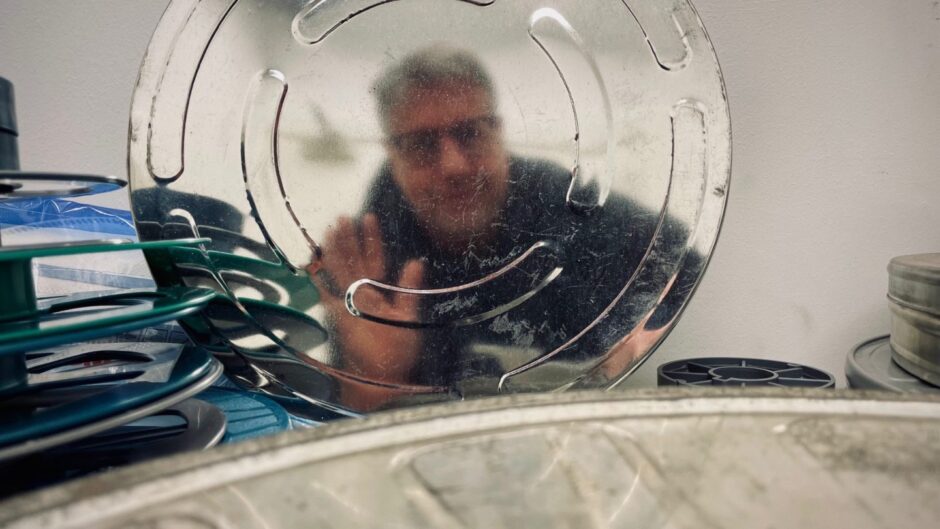 Archivist Barry Sullivan reflected in one of the canisters.