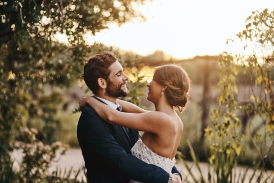 couple embraces in the countryside after planning a wedding in Scotland