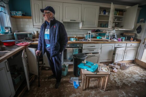 Ian Stewart who lives on River Street, standing last year in his home which was is completely ruined by flood water. Image: Mhairi Edwards/DC Thomson