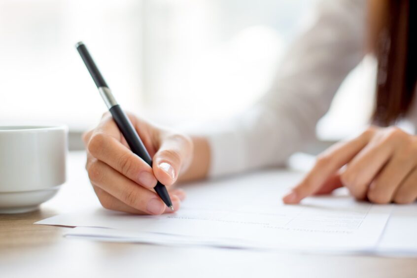 Hand of woman signing a document.