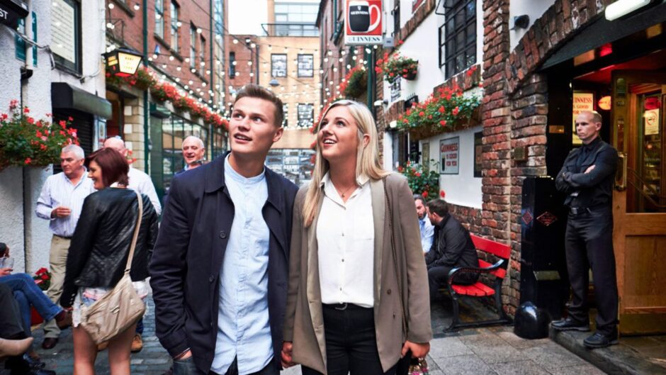 couple explores a street in Belfast after going on one of the bus trips to Christmas markets