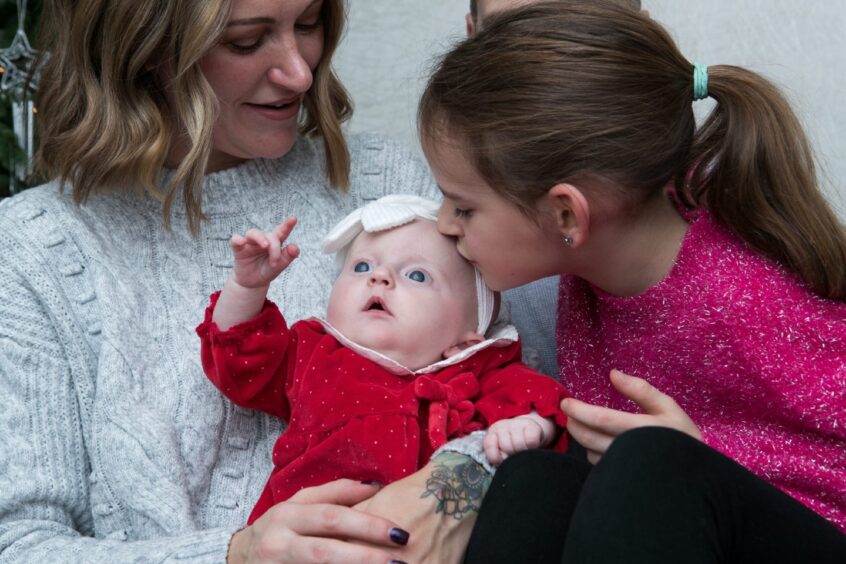 A kiss for Remi from big sis Zara.