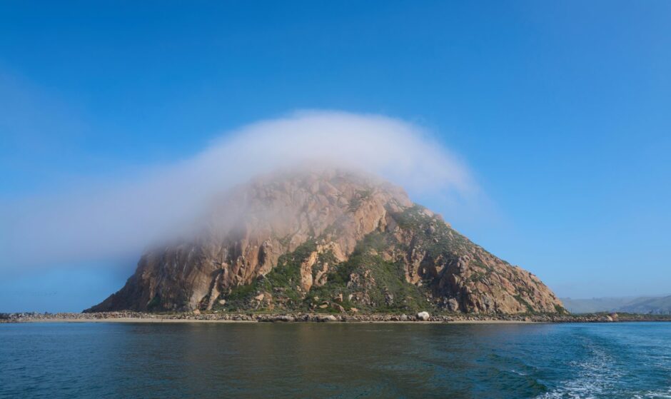 A cloud passes over Morro Rock in Morro Bay, California.