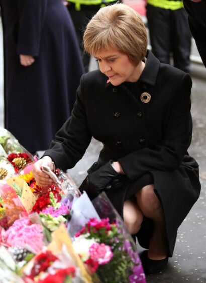 Nicola Sturgeon views flowers left near to the scene of the crash in 2014.