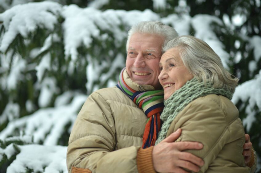 happy older couple in a snowy woodland