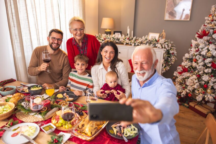 happy family taking a selfie at Christmas dinner