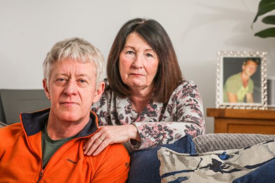 Davy Cornock and wife Margaret at home with a framed picture of David. Image: Mhairi Edwards/DC Thomson