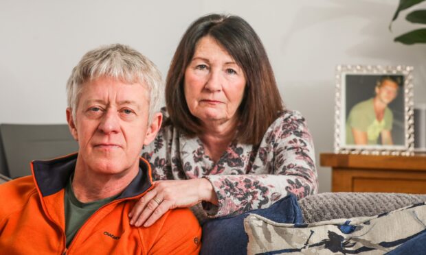 Davy Cornock and wife Margaret at home with a framed picture of David. Image: Mhairi Edwards/DC Thomson