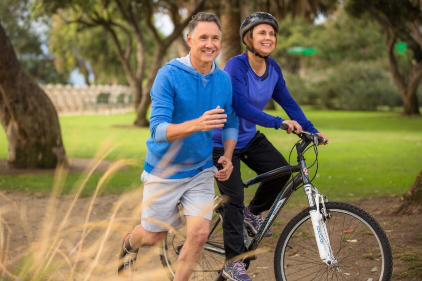 middle aged couple exercising in park