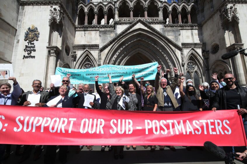 Former post office workers celebrate outside the Royal Courts of Justice after their convictions were overturned in 2021.
