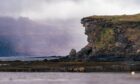 A rocky outcrop on Inch Kenneth as rain falls in the distance.