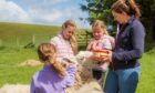 Cowden Farm owner Liz Phillips helps the children feed the Motley Crew at Cowden Farm.