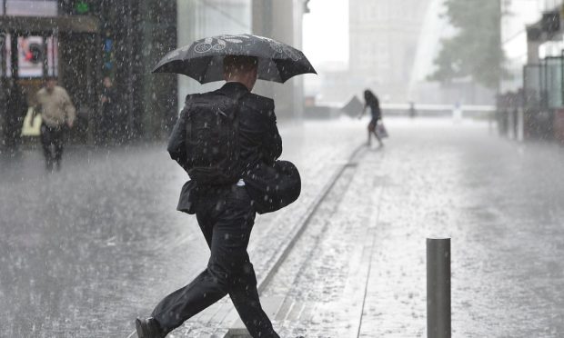 Heavy rain with man holding umbrella.