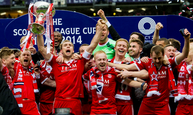 Russell Anderson celebrates with his Aberdeen team-mates as he lifts the Scottish League Cup trophy.