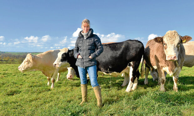 NFU president Minette Batters on farmland with cows.