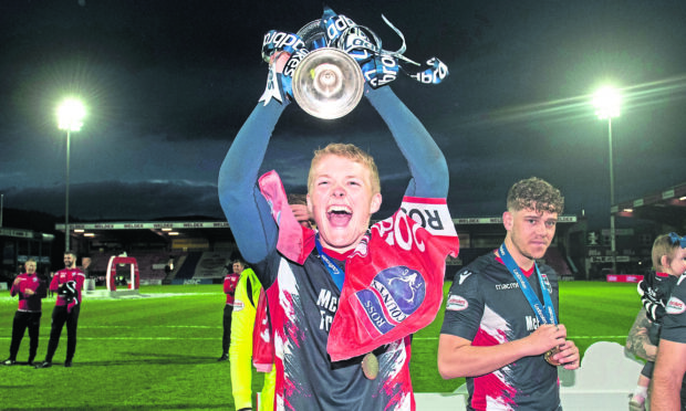 Ross County's Tom Grivosti holds aloft the Championship title in 2019.