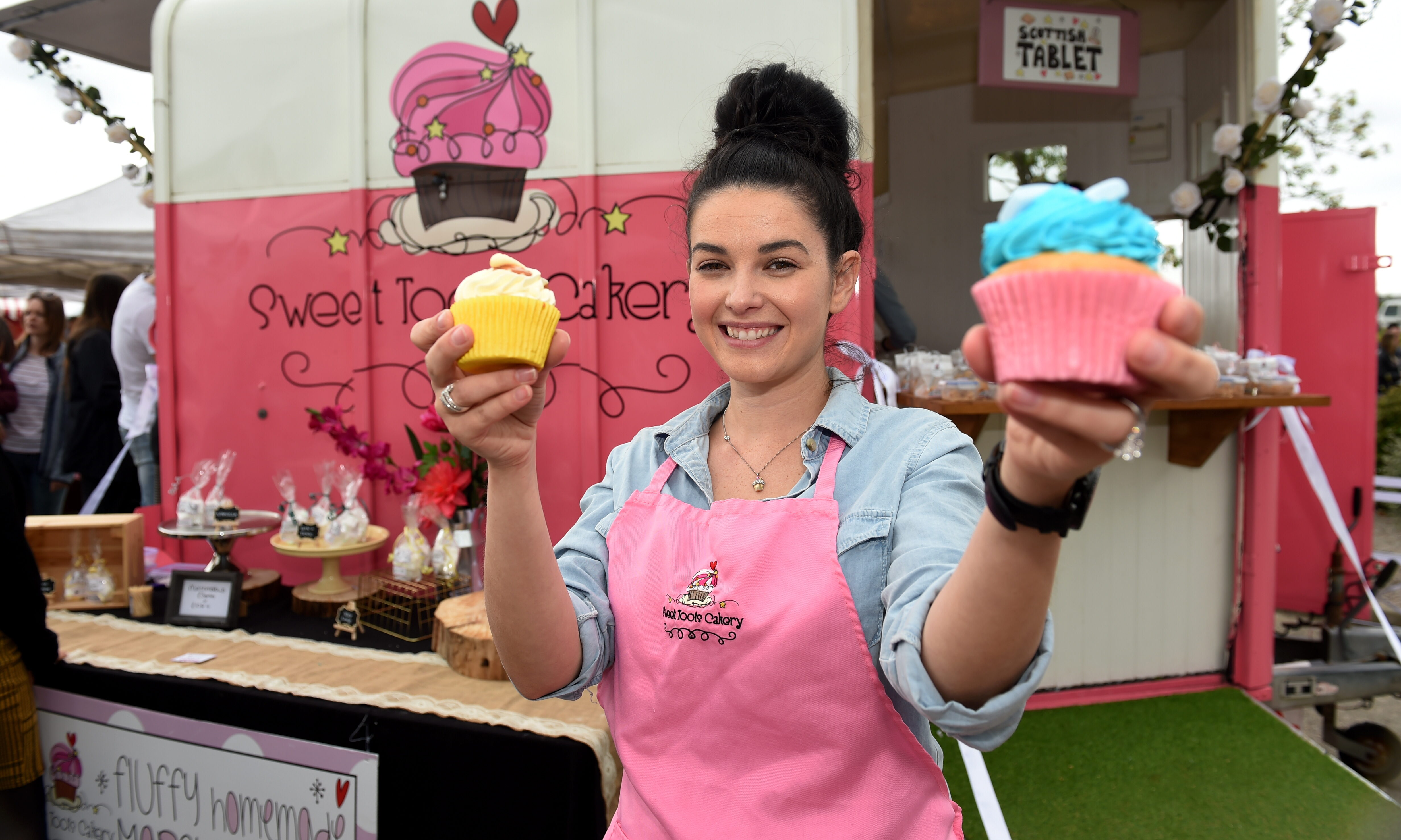 Danielle holding cupcakes in front of her Sweet Toots Cakery horsebox