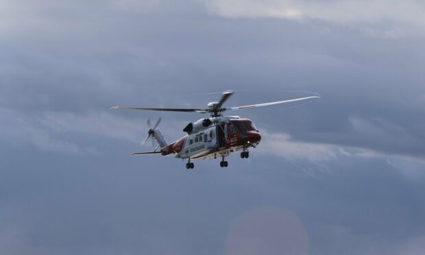 A Coastguard helicopter being used to help rescue a walker who had fallen down a cliff in Shetland.