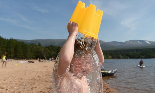 Klay Sutherland enjoys a shower of cold Loch Morlich water. Picture by Sandy McCook