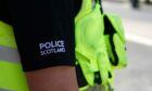 Stock image police featuring the Police Scotland logo on an officer's sleeve
