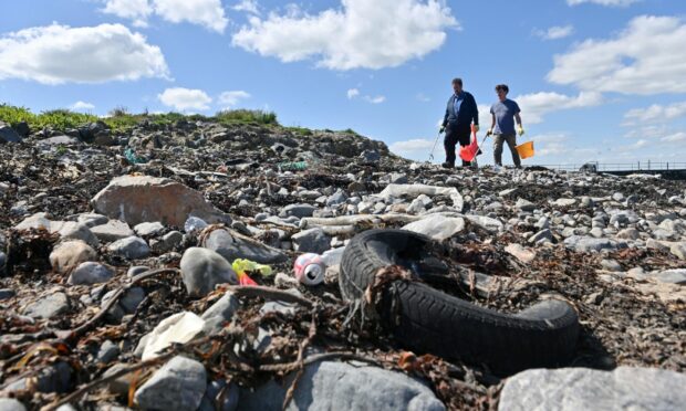 Oil and gas workers get their hands dirty to clean up one of the most polluted beaches in the north-east