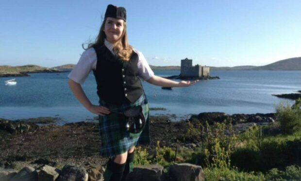 Eilidh MacLeod in front of Kismul Castle, Castlebay, wearing her piping uniform.