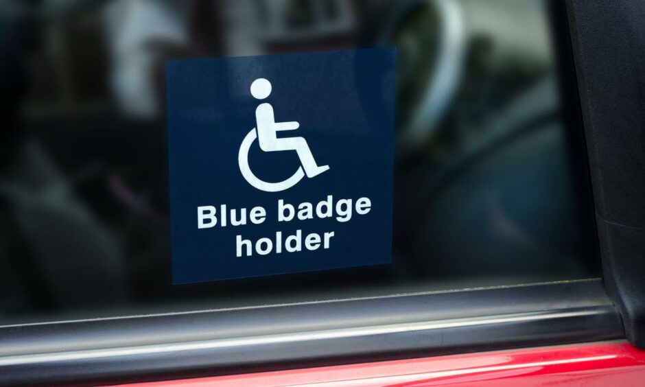 'Blue badge holder' sign on car.