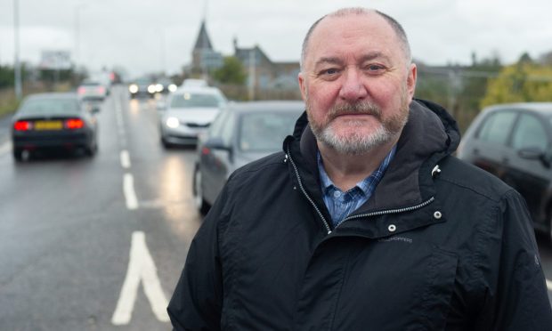 Elgin South councillor John Divers in front of a busy road