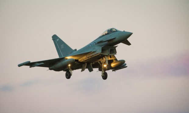 A RAF Lossiemouth Typhoon in the sky at dusk.