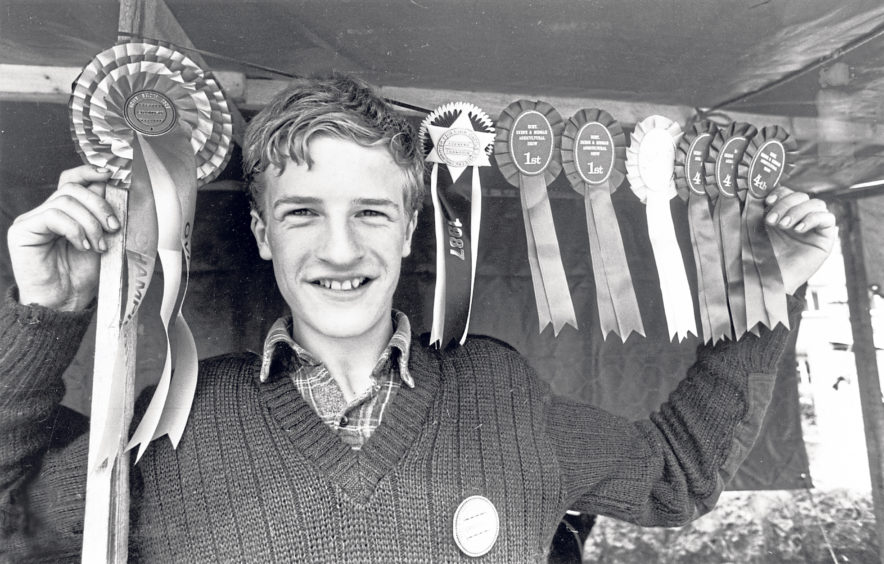 Show president Pat Kemp’s 16-year-old son Peter with a string of rosettes the family won at the event