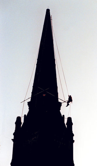 1998: A steeplejack carries out maintenance work at Langstane Kirk