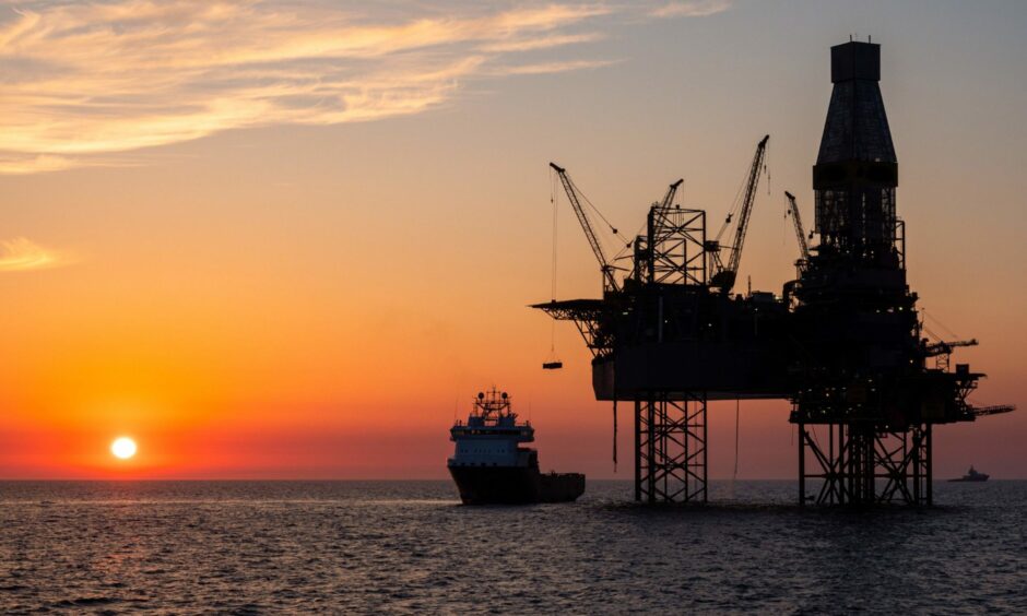 Oil platform and a supply vessel in the North sea during sunset
