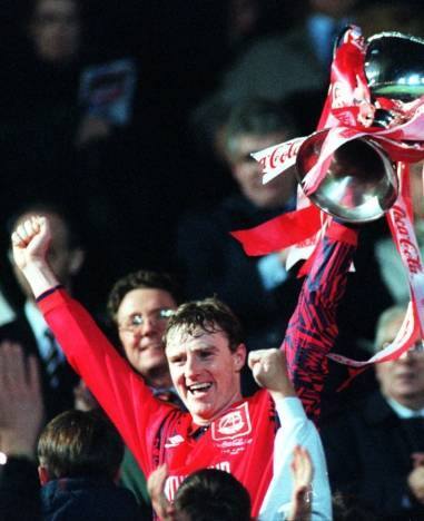 1995: Aberdeen skipper Stewart McKimmie just loves playing this captain's part as he hoists the Coca-Cola Cup before the delighted Dons support.