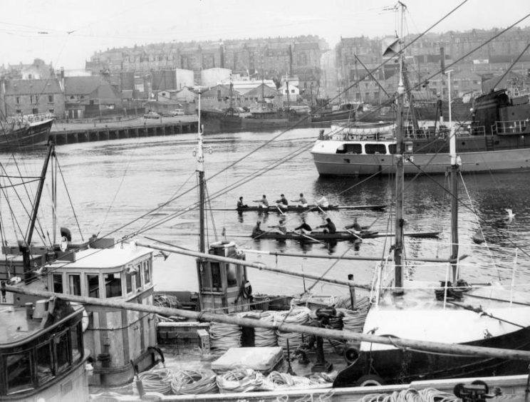 1965: Rowers make their way between trawlers at Aberdeen Harbour in this picture of the Inter Club Regatta on the River Dee.