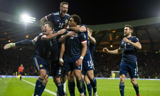 Scotland team celebrates after Che Adams scores against Denmark in 2021.
