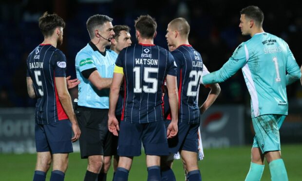 Ross County players protest referee Craig Aitken's decision to send off Harry Clarke against Dundee United.