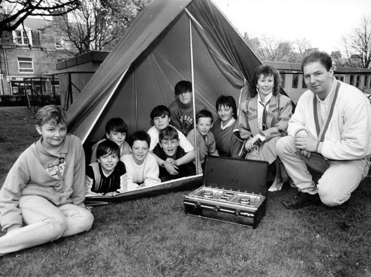 1988: Chevron HR representative Trish Will presents Fersands and Fountain Urban Aid project's Ian Armstrong with a tent and camping stove, bought with a £150 donation made by the oil company. Looking on are some of the project members.