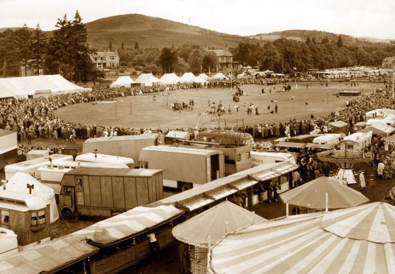 1963: A large crowd watches the field events at the Aboyne Highland Games in August, 1963, on what would appear to be a cold, wet day judging by the amount of people wearing waterproofs. This year's games are on Saturday, August 2.