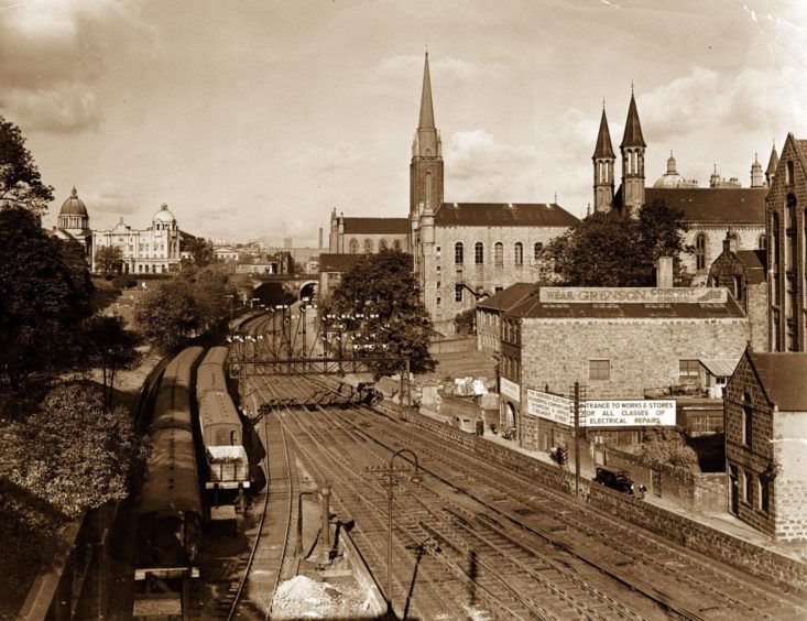 1954: Looking along the Denburn from Aberdeen's Union Bridge towards the Triple Kirks and HM Theatre in October, 1954. An array of railway signals straddles the then busy railway lines with a siding on the left next to Union Terrace Gardens.
