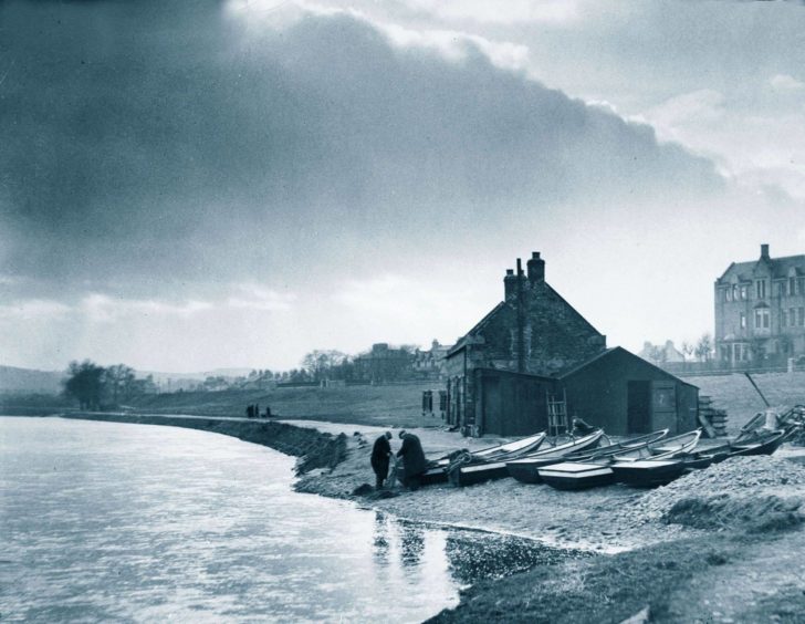 Salmon fishers at work tending their nets in late afternoon at the bothy by the River Dee on Riverside Drive, Aberdeen, in 1936.