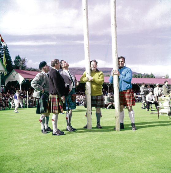 1971: Judges and competitors get ready for the iconic tossing the caber contest, a highlight of any games.