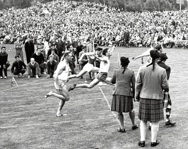 1960: Crowds gather to watch the runners crossing the line during the 100 yards sprint.