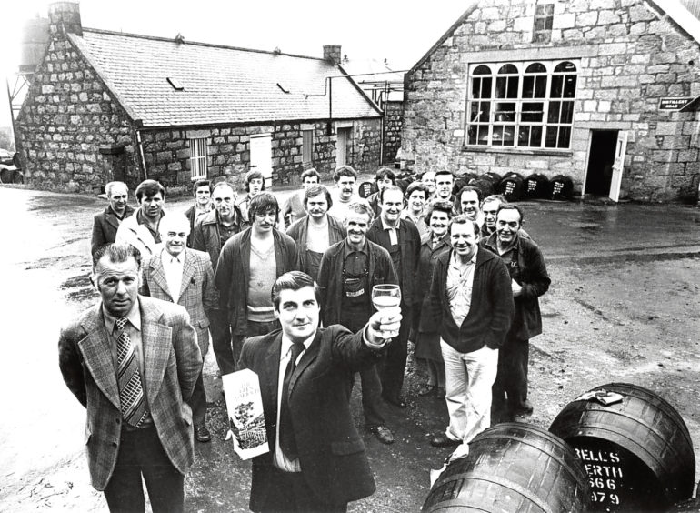 1979: Glen Garioch Distillery manager Willie MacNeill toasts a dram of their malt whisky as under-manager Ian Fyfe, left, looks on.