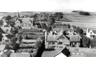 1962: Not an aerial view, but the next best thing. This is how New Deer looks from the top of St Kane's Church, looking across the village, with New Deer School in the foreground and the monument on the Hill of Culsh in the distance.