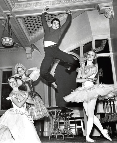 1977: A break during HMT rehearsals, but ballet star Graham Bart is still flying high, watched by Veronica Butcher, Wendy Roe and Patricia Merrin.