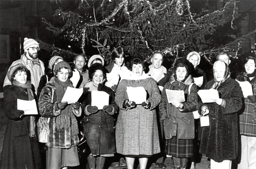 1981: Carol singers from the Aberdeen Opera Company sing for travellers at Aberdeen railway station.