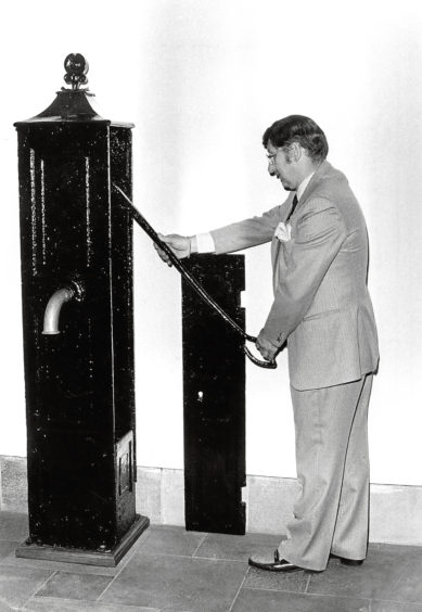 1983: Trinity Hall steward/housekeeper Fred Mann examines the restored Hammermen’s Well, which stood for many years in Golden Square.