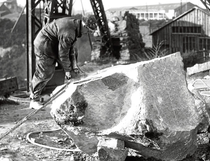 1948: D Donaldson works on a big block of granite. Note the ladder used for getting on to the top.