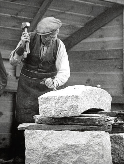 1930s: A worker in the 1930s shapes a granite block with a hammer and chisel