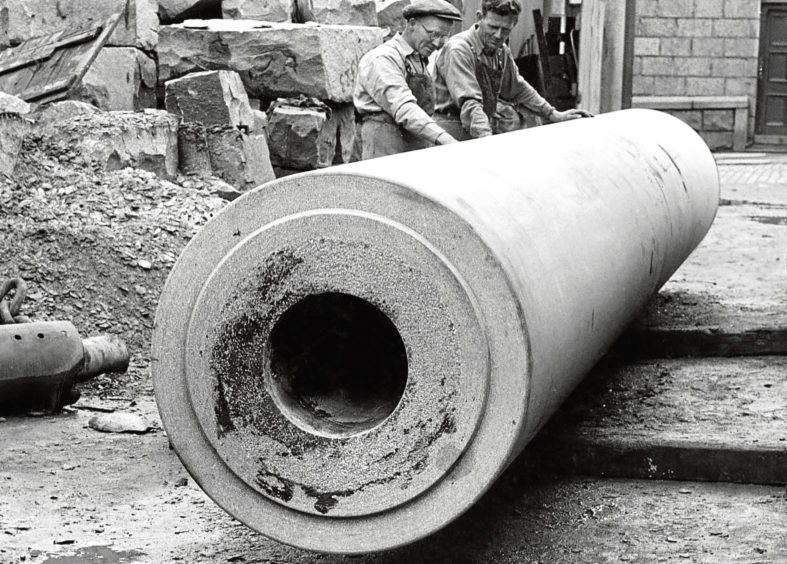 1954: Workmen examine a granite roller at a yard in Aberdeen.
